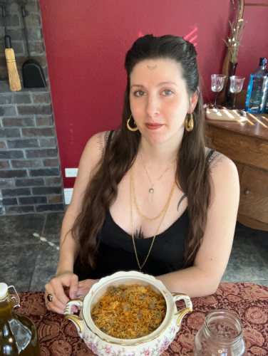 Picture of Faith at a table with a beautiful china-ware pot filled with calendula flowers